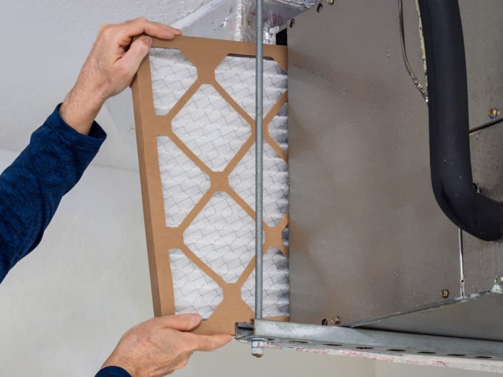 This image is a tech changing a furnace filter.