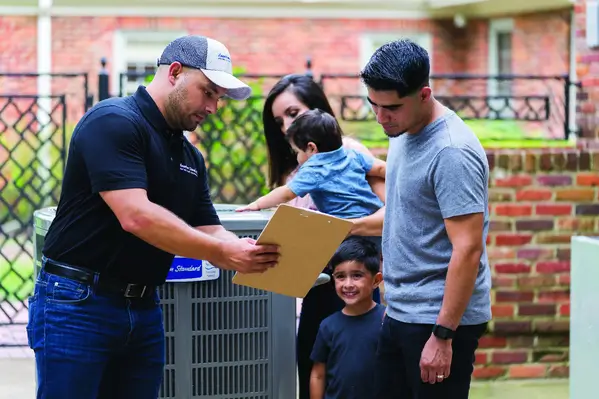 HVAC technician discussing heating and cooling options with a family in St. Clair Shores, MI.